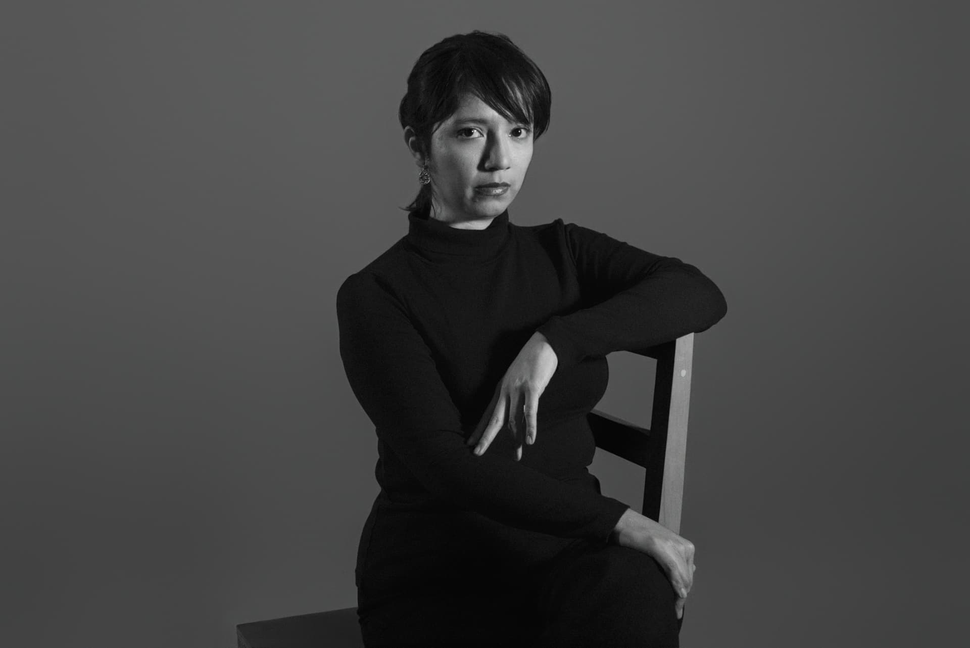 Retrato en blanco y negro de Olivia Teroba sentada junto a una silla